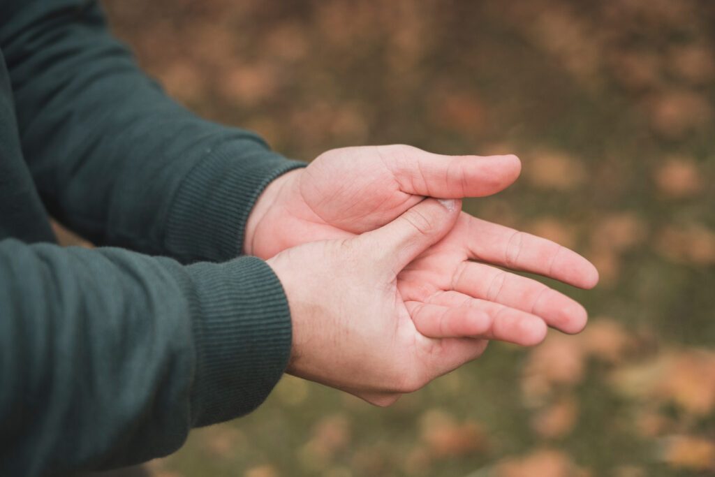 ภาพคนจับบริเวณมือ สื่อถึงอาการชาบริเวณปลายมือ เจ็บมือ